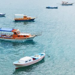 Boats float in the calm blue sea water in Turkey.