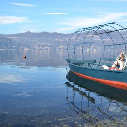 An old fishing boat in the lake with mountains in the background