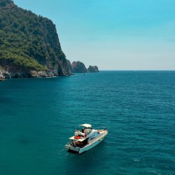 Sailboat in the sea in the evening sunlight over beautiful big mountains background, luxury summer adventure, active vacation in Mediterranean sea, Turkey